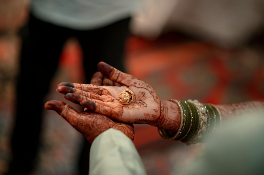 Bride and groom holding hands with wedding mehendi design